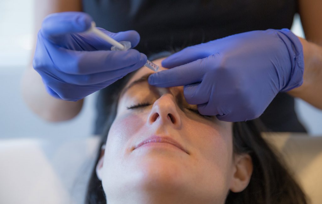 the difference between botox and fillers - woman receiving a botox injection