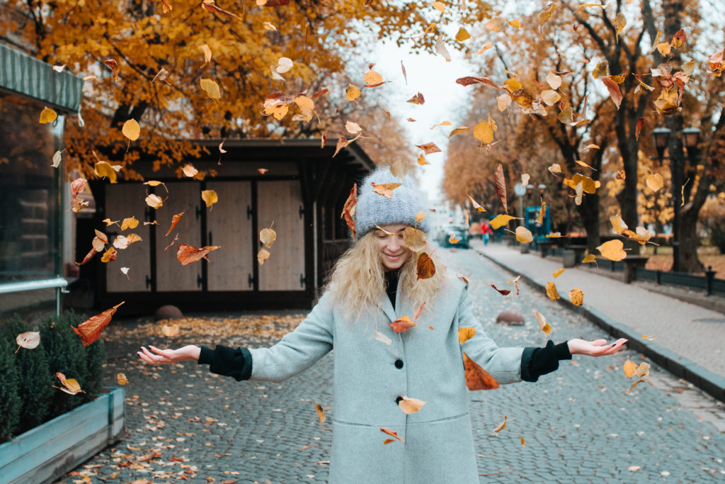 woman tossing leaves after receiving a hydrafacial md in lone tree